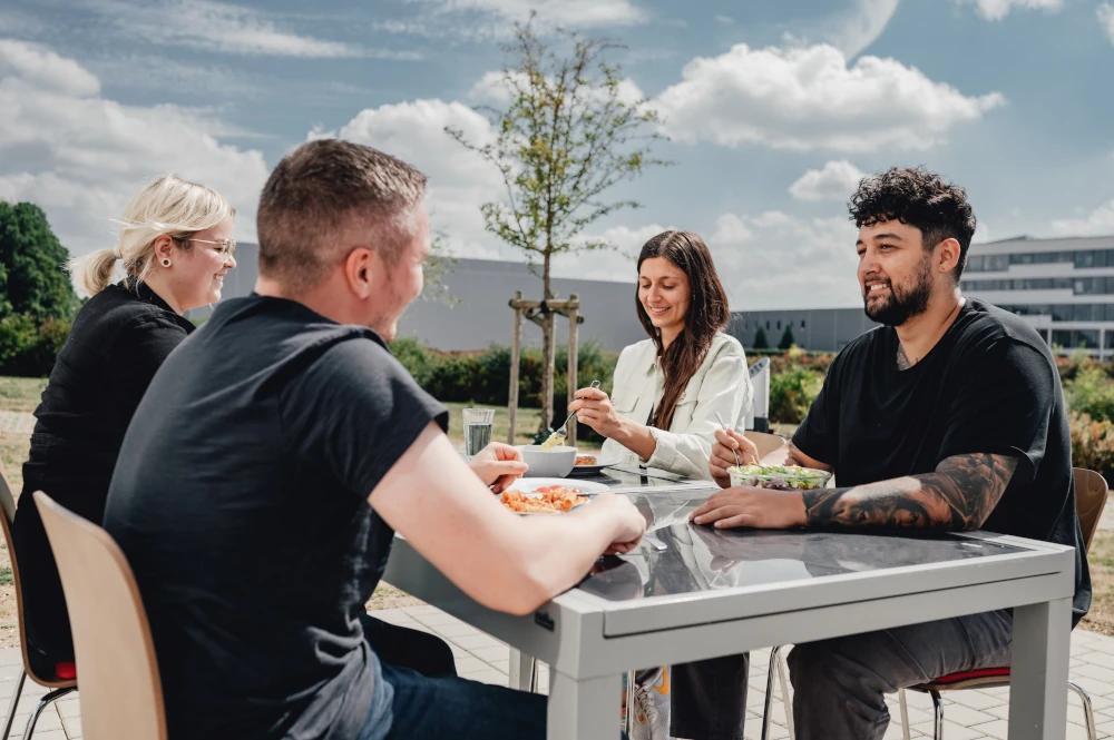 Mitarbeiter beim Mittagessen auf der Terrasse