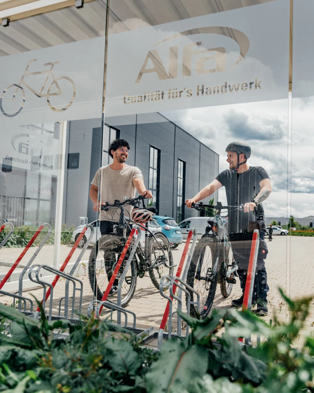 Zwei Mitarbeiter stellen ihre Fahrräder ab